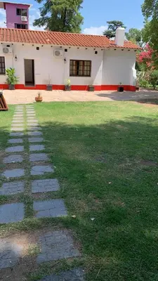 a grassy yard with a house in the background at HOTEL COLONIAL in Villa Carlos Paz
