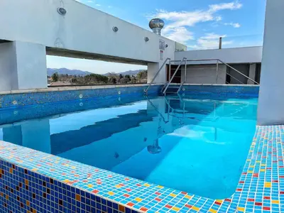 a large swimming pool with blue water at Edificio Tempo in Villa Carlos Paz