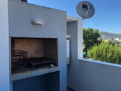 a room with a fireplace on the side of a building at Edificio Tempo in Villa Carlos Paz