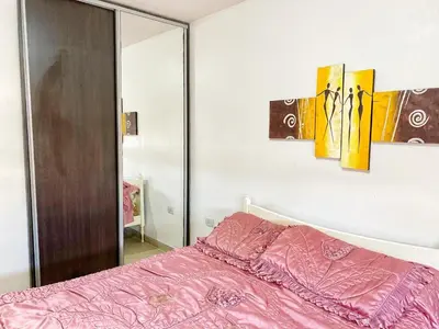a bedroom with a pink bed and a mirror at Edificio Tempo in Villa Carlos Paz