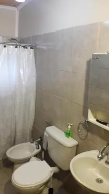 a bathroom with a white toilet and a sink at Cabaña Trapiche San Luis in Trapiche
