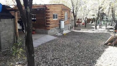 a log cabin in a yard with a tree at Cabaña Trapiche San Luis in Trapiche