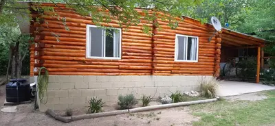a log cabin with two windows on the side of it at Cabaña Trapiche San Luis in Trapiche