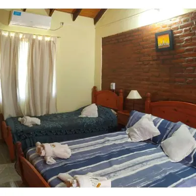 two beds with stuffed animals on them in a bedroom at Cabañas Peñihue in Carpintería