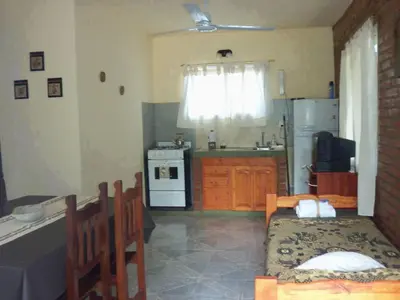 a kitchen with a table and a kitchen with a stove at Cabañas Peñihue in Carpintería