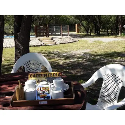 a tray with cups and dishes on a table with chairs at Cabañas Peñihue in Carpintería