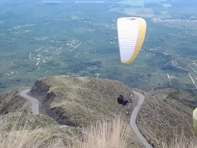 a person flying a parachute over a mountain at Cabañas Peñihue in Carpintería