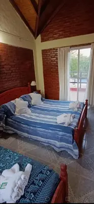 a bedroom with two beds with towels on them at Cabañas Peñihue in Carpintería