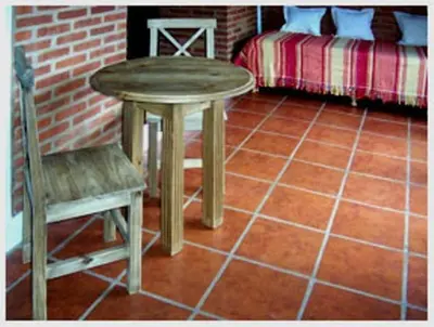 a table and a chair in a room with a bed at Costa Serrana Apart Hotel in Mina Clavero