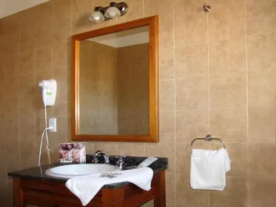 a bathroom with a sink and a mirror at Costa Serrana Apart Hotel in Mina Clavero