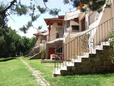 a house with stairs leading up to a yard at Costa Serrana Apart Hotel in Mina Clavero