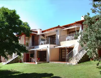 an exterior view of a building with stairs and grass at Costa Serrana Apart Hotel in Mina Clavero
