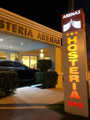 a sign in front of a store with a car at Hosteria Arenas in Mina Clavero