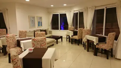a dining room with tables and chairs and windows at Hosteria Arenas in Mina Clavero