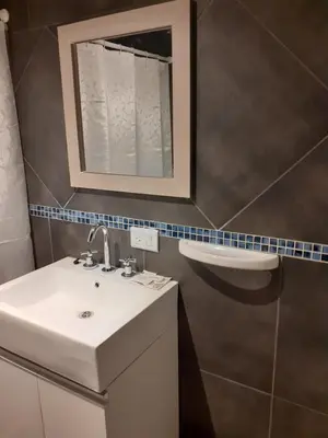 a bathroom with a sink and a mirror at Hosteria Arenas in Mina Clavero