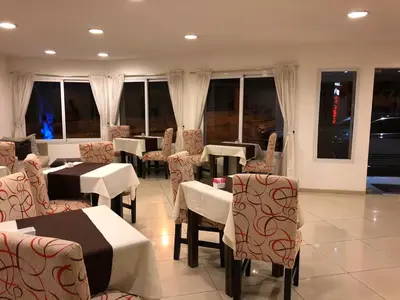 a dining room with tables and chairs and windows at Hosteria Arenas in Mina Clavero