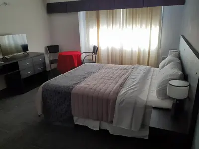 a bedroom with a bed and a dresser and a window at Hosteria Arenas in Mina Clavero