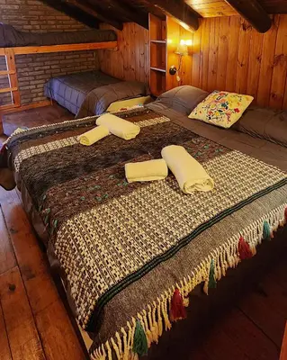 two beds in a room with two at Cabañas Cultura Serrana in Santa Rosa de Calamuchita