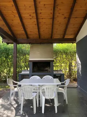 a white table and chairs on a patio with a stove at Cabañas La Herradura in Villa Ciudad Parque