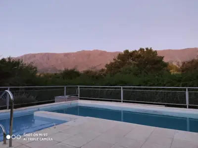a swimming pool with a view of the mountains at Cabaña Negusa in Merlo