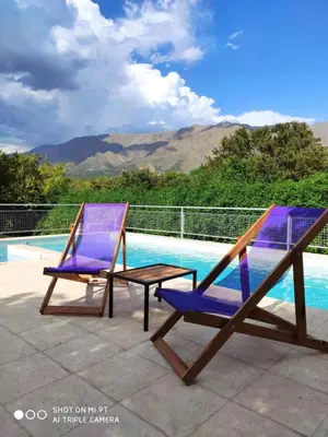 two chairs and a table next to a swimming pool at Cabaña Negusa in Merlo