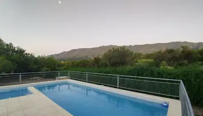 a swimming pool with a view of the mountains at Cabaña Negusa in Merlo