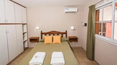 a bedroom with a bed with two pillows on it at Cabañas Las Pircas in Villa del Dique