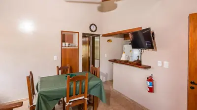 a dining room with a table and a tv at Cabañas Las Pircas in Villa del Dique