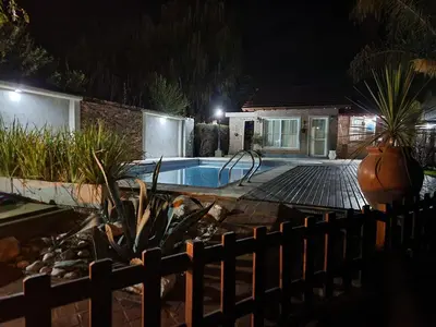 a house with a swimming pool at night at Cabañas Las Pircas in Villa del Dique