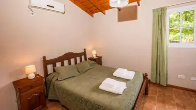 a bedroom with a bed with two towels on it at Cabañas Las Pircas in Villa del Dique