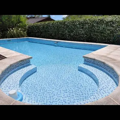 a swimming pool with blue water in a yard at Cabañas Las Pircas in Villa del Dique