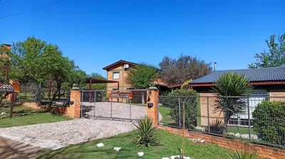 a fence in front of a house at Cabañas Lo de Alberto in Santa Rosa de Calamuchita