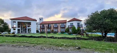 a large building with a playground in front of it at Hotel Colores in Merlo