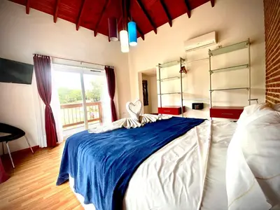 a bedroom with a large bed with a blue blanket at Hotel Colores in Merlo