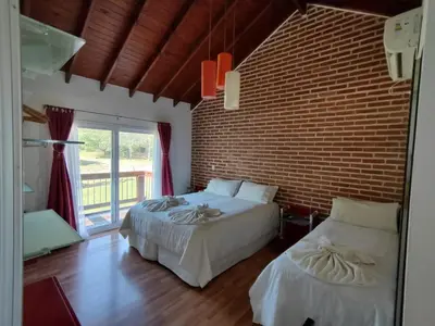 a bedroom with two beds and a brick wall at Hotel Colores in Merlo