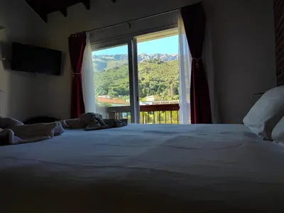 a bedroom with a large bed with a large window at Hotel Colores in Merlo