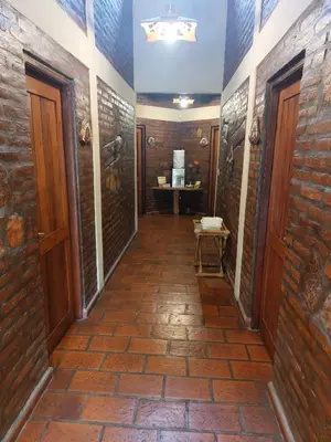a hallway with brick walls and wooden doors at CABAÑAS VIEJO VIVERO in Mina Clavero