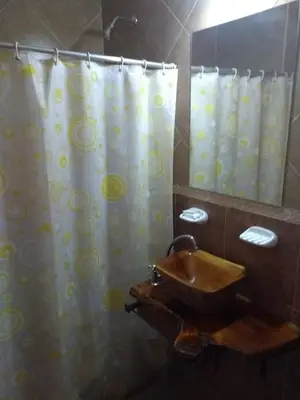 a bathroom with a sink and a shower curtain at Barranca Del Indio in Merlo