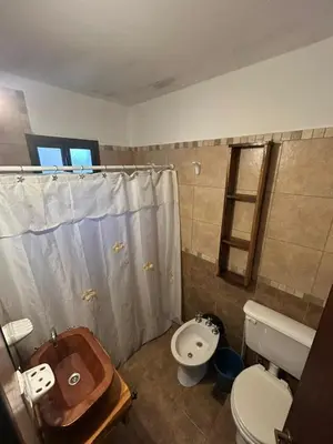 a bathroom with a toilet and a sink at Barranca Del Indio in Merlo