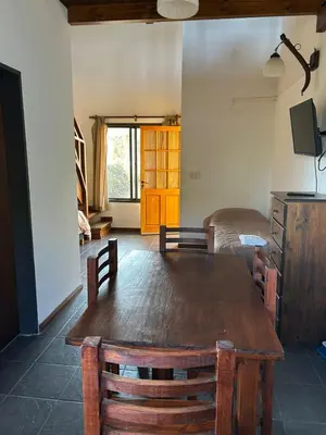 a room with a wooden table and a bed at Barranca Del Indio in Merlo