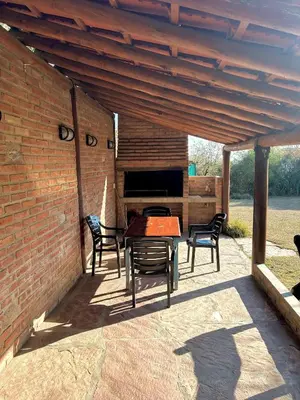 a patio with chairs and a table and a piano at Barranca Del Indio in Merlo