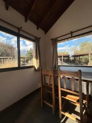 a room with two windows and a table and chairs at Barranca Del Indio in Merlo
