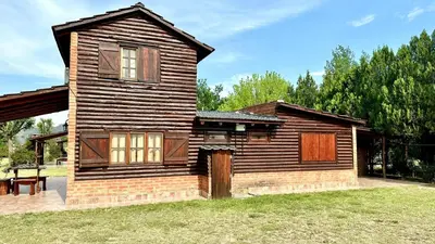 a wooden house with a yard at Cabañas El Trigal in Nono