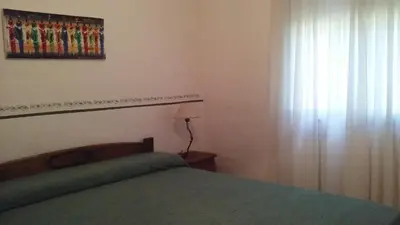 a bedroom with a bed and a window with a curtain at Soleaditos in Mina Clavero