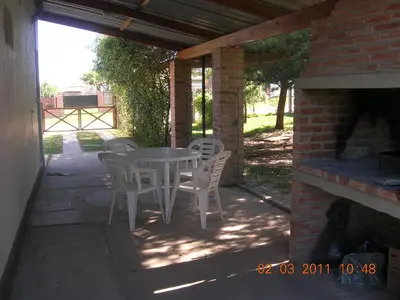a patio with a table and chairs and a brick building at Soleaditos in Mina Clavero