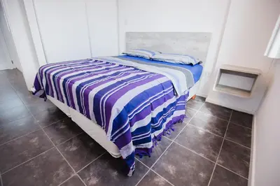 a bedroom with a bed with a striped blanket on it at Apart FJL in Río Cuarto