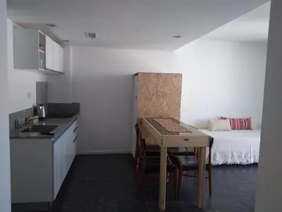 a kitchen with a table and a bed in a room at Apart FJL in Río Cuarto