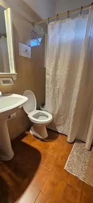 a bathroom with a toilet and a sink and a shower at Depto VCP Rental in Villa Carlos Paz