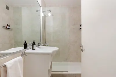 a white bathroom with a sink and a shower at Departamentos Lugar in Cordoba
