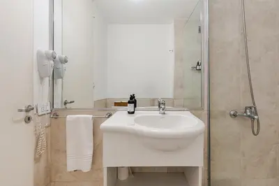 a bathroom with a white sink and a shower at Departamentos Lugar in Cordoba